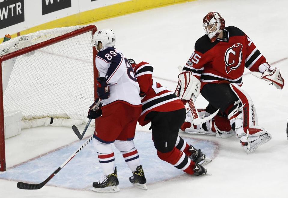 Columbus Blue Jackets center Sam Gagner, left, scores a goal on New Jersey Devils goalie Cory Schneider, right, during the third period of an NHL hockey game, Sunday, March 5, 2017, in Newark, N.J. The Blue Jackets won 3-0. (AP Photo/Julio Cortez)