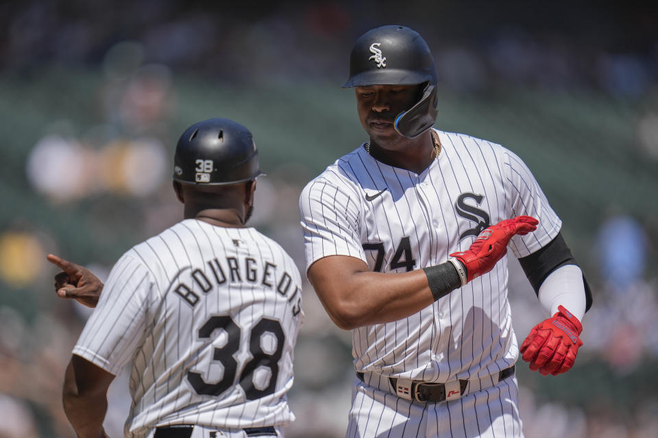 Chicago White Sox designated hitter Eloy Jiménez, right, slaps hands with first base coach Jason Bourgeois after he hit a single during the fifth inning of a baseball game against the Minnesota Twins, Wednesday, July 10, 2024, in Chicago. (AP Photo/Erin Hooley)