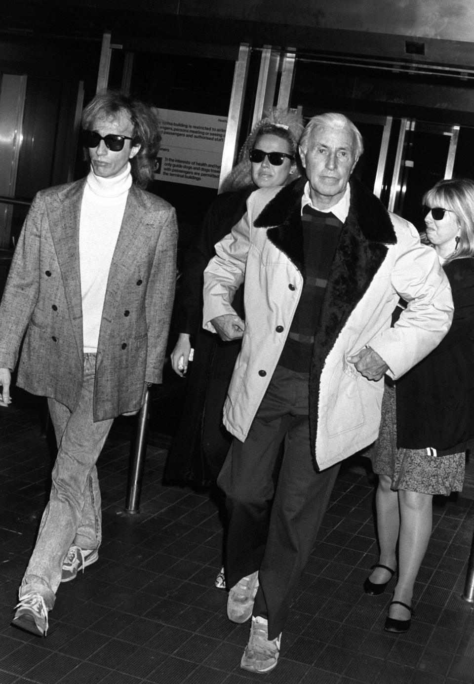 Robin Gibb with father Hugh at London’s Heathrow Airport after the patriarch flew in from LA following Andy’s death. (Credit: PA Images via Getty Images)