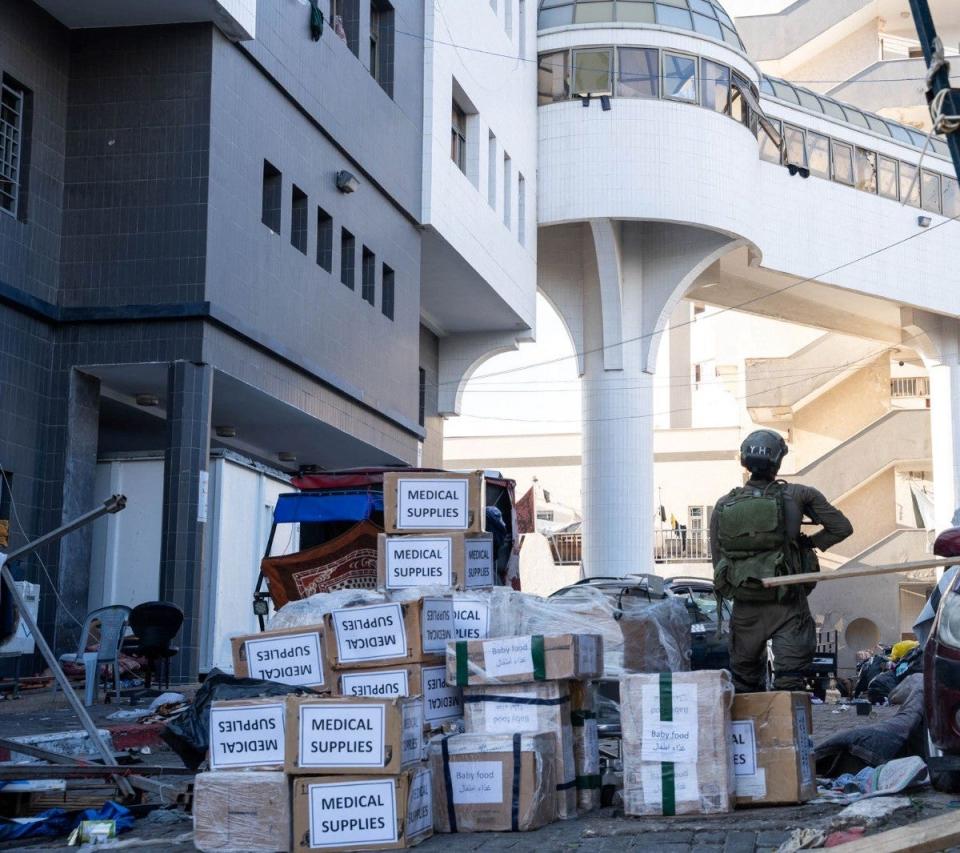 An Israeli soldier standing outside Al-Shifa hospital next to boxes of medical supplies (Israeli Defence Forces/AFP via G)