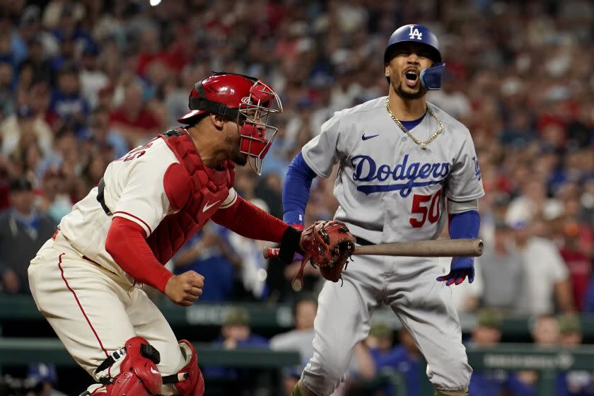 St. Louis Cardinals catcher Willson Contreras, left, celebrates as Los Angeles Dodgers&#39; Mookie Betts reacts.