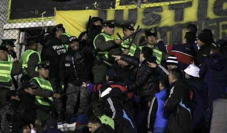 Bolivian police try to stop fans of Argentina's San Lorenzo and Bolivia's Bolivar from fighting during the Copa Libertadores second leg semi-final soccer match in La Paz, July 30, 2014. REUTERS/David Mercado