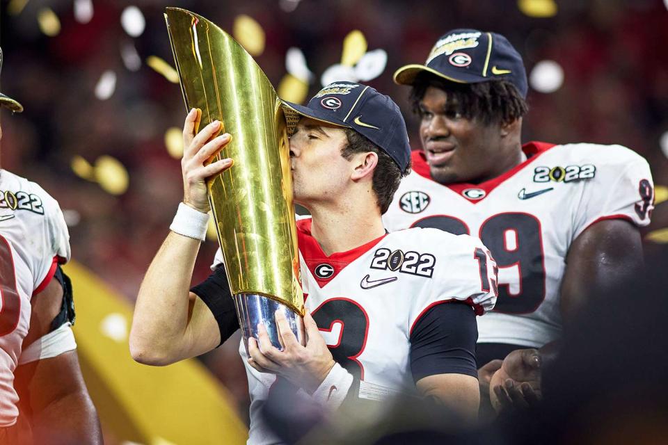 Georgia Bulldogs QB Stetson Bennett (13) celebrates and holds the national championship trophy after the Alabama Crimson Tide versus the Georgia Bulldogs in the College Football Playoff National Championship, on January 10, 2022, at Lucas Oil Stadium in Indianapolis, IN.