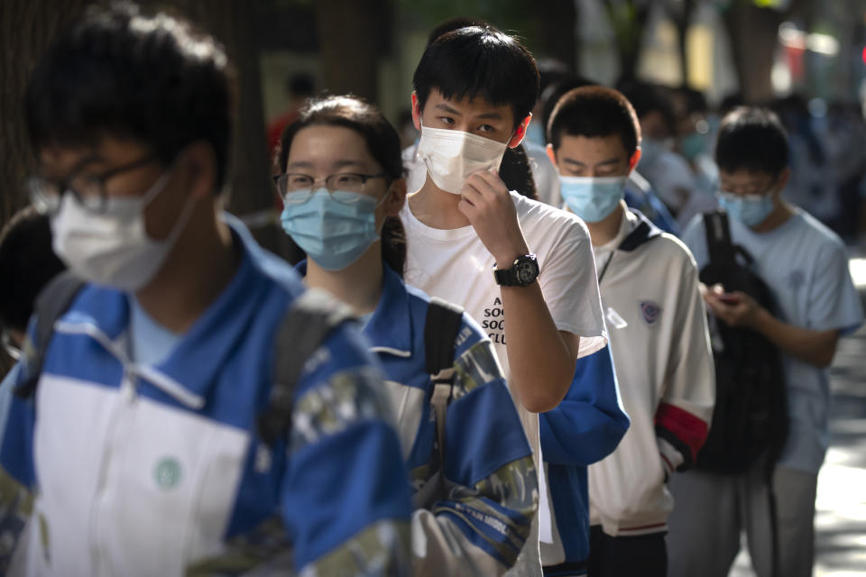 Students wearing face masks to protect against the new coronavirus line up for the first day of China's national college entrance examinations, known as the gaokao, in Beijing, Tuesday, July 7, 2020. China's college entrance exams began in Beijing on Tuesday after being delayed by a month due to the coronavirus outbreak. (AP Photo/Mark Schiefelbein)