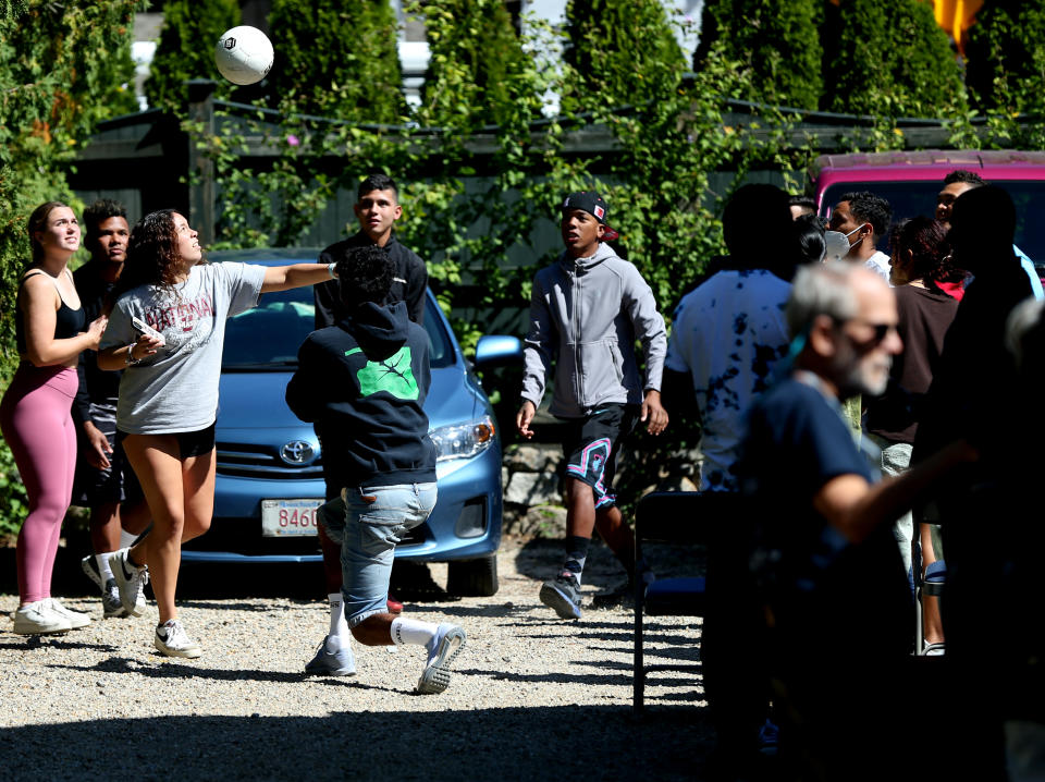Martha's Vineyard, MA - September 15: Volunteers and migrants tossed a soccer ball around at the St. Andrew's Parrish House in Edgartown, where migrants were being fed lunch with donated food from the community. Two planes of migrants from Venezuela arrived suddenly Wednesday night on Martha's Vineyard. (Photo by Jonathan Wiggs/The Boston Globe via Getty Images)