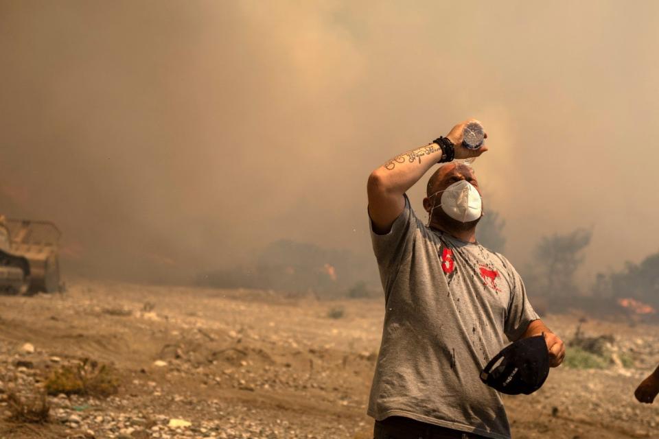 A volunteer cools himself during a wildfire in Vati village, on the Aegean Sea island of Rhodes, southeastern Greece (AP)