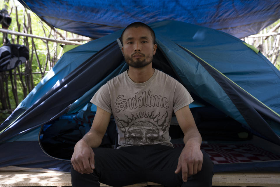 Chen Wang, a Chinese migrant currently homeless in New York, poses for a photo in front of his tent on Friday, May 3, 2024. Chen came to the U.S. after getting criminally admonished by Chinese police for anti-Chinese Communist Party posts on X, formerly known as Twitter. The daily struggle to find work for Chinese immigrants living illegally in New York is a far cry from the picture Donald Trump and other Republicans have sought to paint about them. Asian advocacy organizations say they're concerned the exaggerated rhetoric could fuel further harassment against Asians in the U.S. (AP Photo/Serkan Gurbuz)