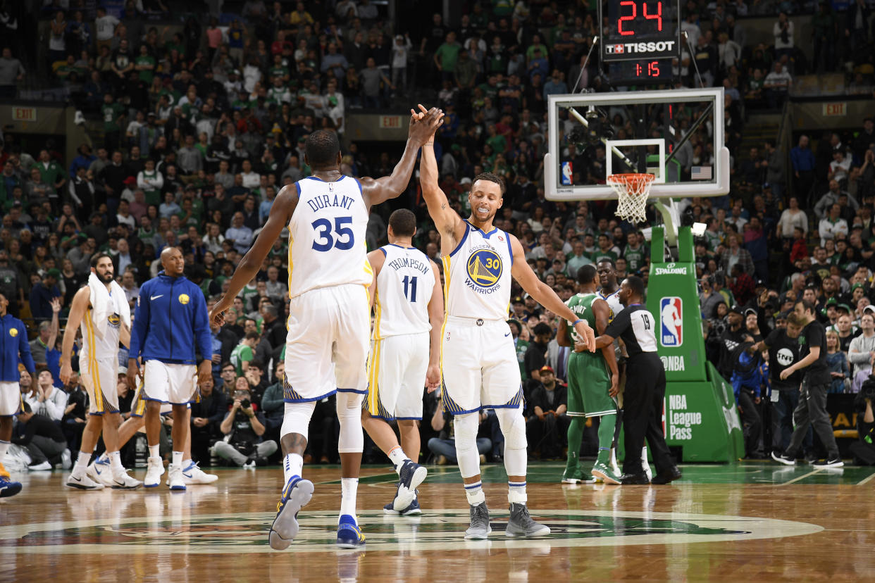 Kevin Durant and Stephen Curry high-five during the first half of the Warriors’ loss to the Celtics on Thursday. (Getty)