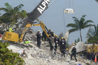 FILE - Rescue crews work at the site of the collapsed Champlain Towers South condo building after the remaining structure was demolished Sunday, in Surfside, Fla., Monday, July 5, 2021. A nearly $1 billion tentative settlement has been reached in a class-action lawsuit brought by families of victims and survivors of last June's condominium collapse in Surfside, Fla., an attorney said Wednesday, May 11, 2022. (AP Photo/Lynne Sladky, File)