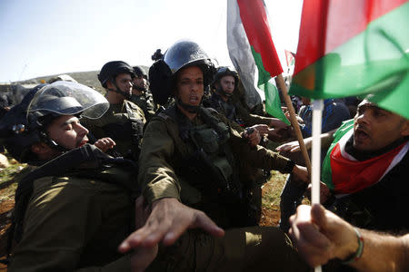 Palestinian protesters argue with Israeli soldiers during a protest against Jewish settlements near the West Bank city of Ramallah December 10, 2014. REUTERS/Mohamad Torokman