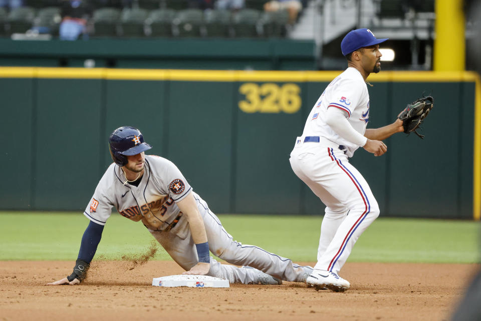 Houston Astros' s Kyle Tucker (30) steals second as Texas Rangers second baseman Marcus Semien, right, defends during the third inning of a baseball game Monday, April 25, 2022, in Arlington, Texas. (AP Photo/Michael Ainsworth)