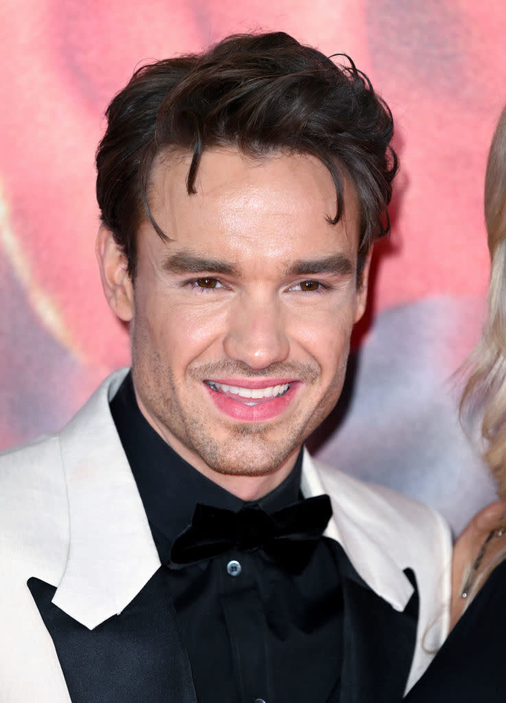 Man with a smile wearing a tuxedo with a black bow tie and contrasting white jacket lapels