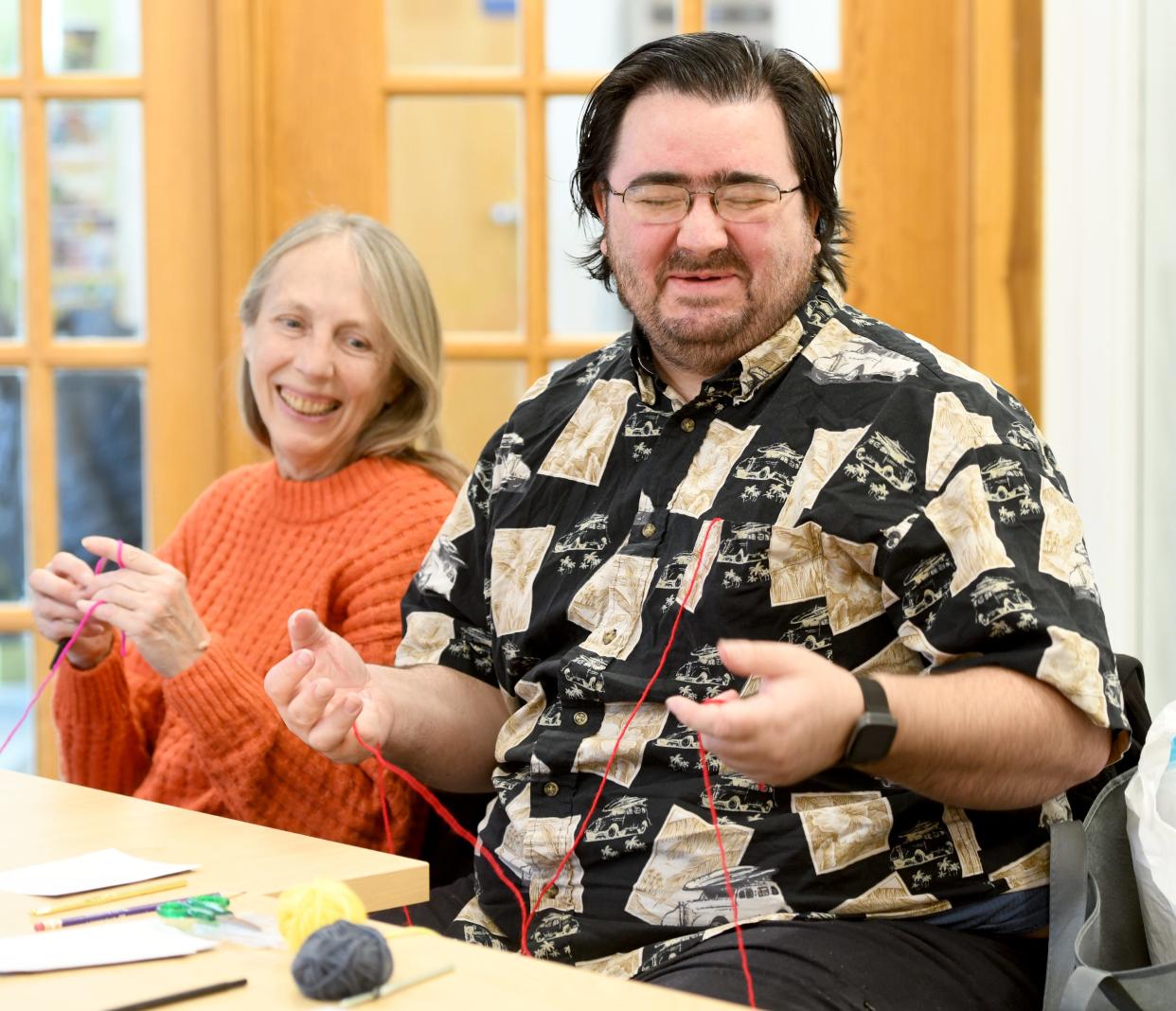 Ronnie Shaneyfelt II of Canton gets wound up as his aunt Linda Ward of Canton looks on during the Knitting and Crochet Club gathering at the Stark Library's DeHoff Memorial Branch in Canton.