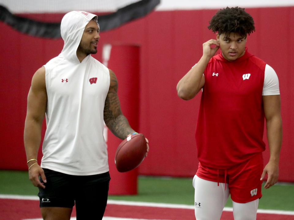 Wisconsin Badgers running backs Chez Mellusi, left, and Isaac Guerendo talk during UW spring football practice at Camp Randall Stadium on March 31.