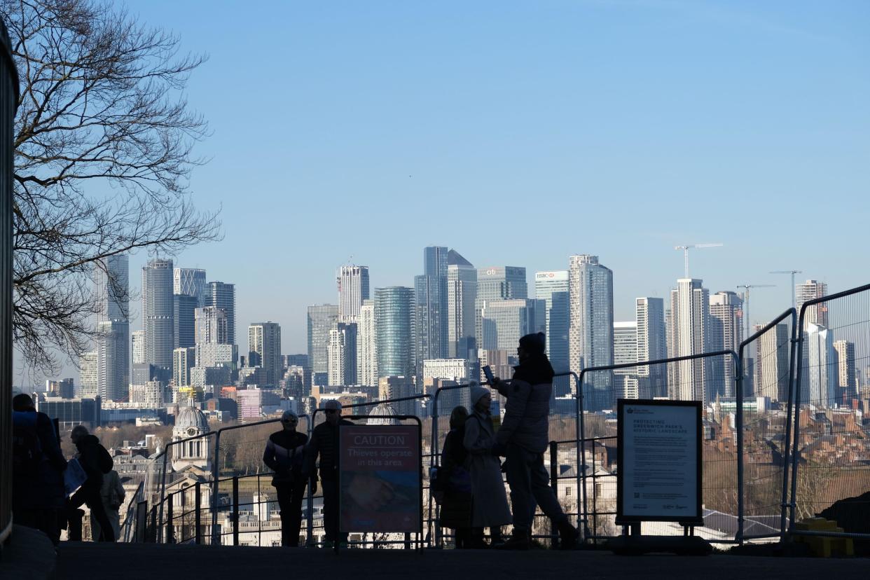 People walking near the Royal Observatory, Greenwich, with the Isle of Dogs in the background