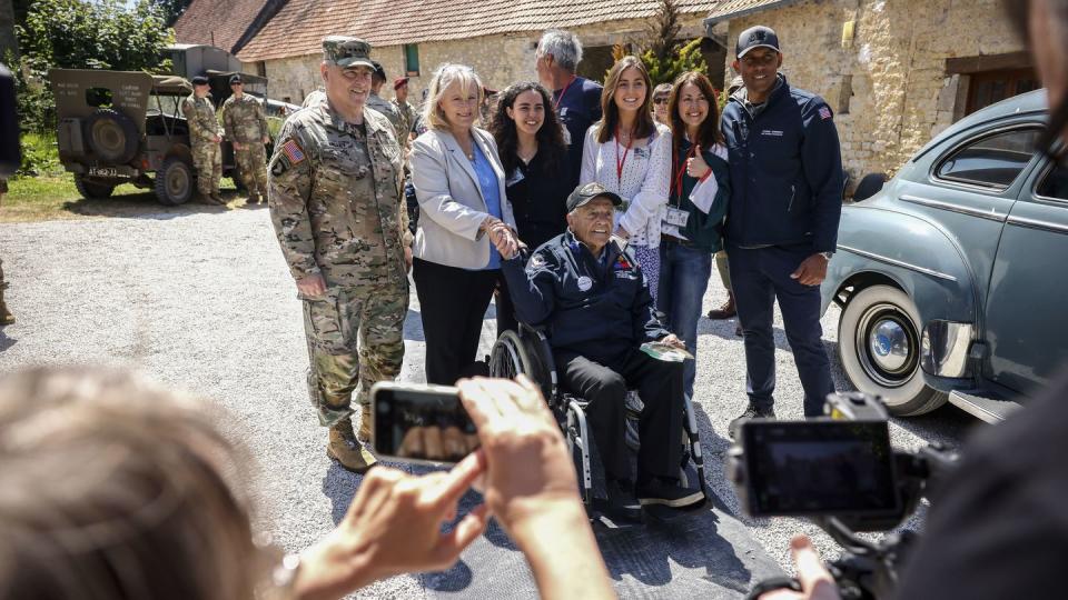 U.S. Gen. Mark Milley, left, his wife Hollyanne Milley, 2nd left, veteran Sgt. Andrew Negra, center on wheel chair, and his family pose for a group photo during a gathering in preparation of the 79th D-Day anniversary in La Fiere, Normandy, France, Sunday, June 4, 2023. (Thomas Padilla/AP)