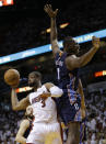 Miami Heat's Dwyane Wade (3) passes the ball as Charlotte Bobcats' Bismack Biyombo (0) defends during the first half in Game 1 of an opening-round NBA basketball playoff series, Sunday, April 20, 2014, in Miami. (AP Photo/Lynne Sladky)