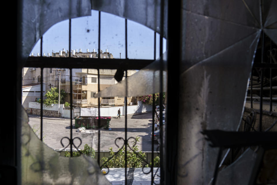 A man walks outside a home belonging to a Torah Nucleus Jewish family which was damaged in recent clashes between Arabs and Jews in the mixed Arab-Jewish town of Lod, central Israel, Wednesday, May 26, 2021. The religious nationalist movement promotes what it says are Jewish values in impoverished cities. But critics say the city's mayor has incited anti-Arab hate, advancing discriminatory policies, and empowering the Torah Nucleus movement in harmful ways. (AP Photo/David Goldman)