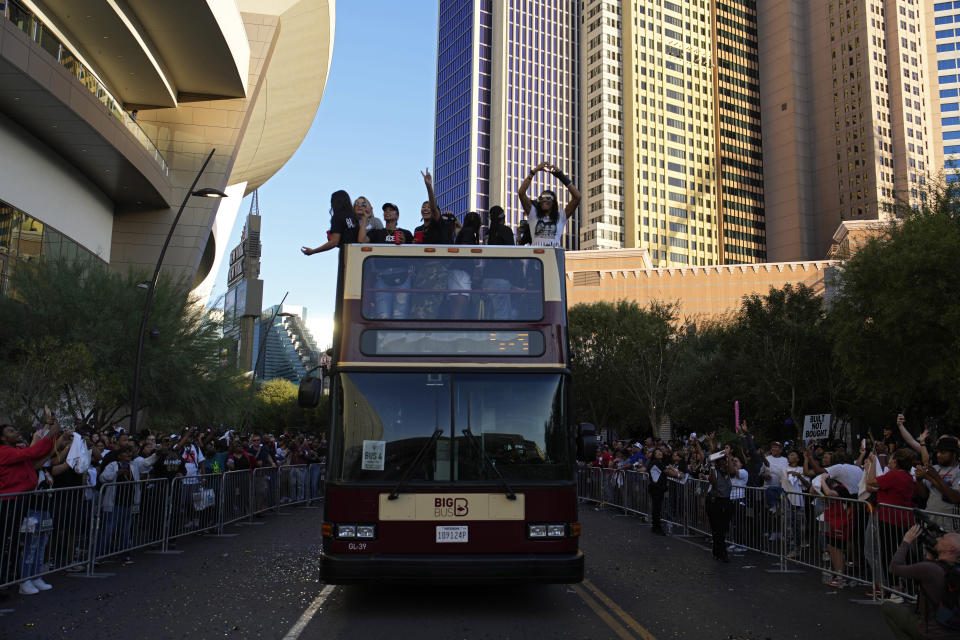 Las Vegas Aces players celebrate while riding a bus during a parade to celebrate the team's WNBA championship Monday, Oct. 23, 2023, in Las Vegas. (AP Photo/John Locher)