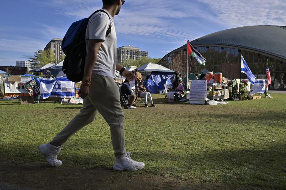 A student walks past a Pro-Palestinian encampment at MIT, Thursday, May 9, 2024, in Cambridge, Mass. MIT has suspended 23 students for participating in the encampment, and police detained at least three during a demonstration at the nearby Stata center, where demonstrators blocked traffic over claims the university was conducting research which would be used for Israeli military drones. (AP Photo/Josh Reynolds)
