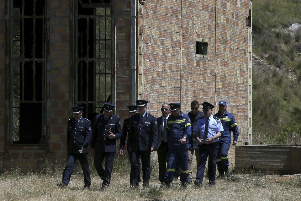 Chief of Cypriot police Zacharias Chrysostomou, center, walks with Cypriot investigators and police officers at a flooded mineshaft where two female bodies were found, outside of Mitsero village, near the capital Nicosia, Cyprus, Monday, April 22, 2019. Police on the east Mediterranean island nation, along with the help of the fire service, are conducting the search Monday in the wake of last week's discovery of the bodies in the abandoned mineshaft and the disappearance of the six year-old daughter of one of the victims. (AP Photo/Petros Karadjias)