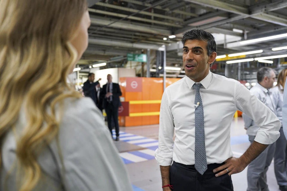 Britain's Prime Minister Rishi Sunak, right speaks to an employee, during a visit to the car manufacturer Nissan, in Sunderland, England, Friday, Nov. 24, 2023. Nissan will invest more than $1.3 billion to update its factory in northeast England to make electric versions of its two best-selling cars. It's a boost for the British government as it tries to revive the country’s ailing economy. The Japanese automaker manufactures the gasoline-powered Qashqai and smaller Juke crossover vehicles at the factory in Sunderland, which employs 6,000 workers. (Ian Forsyth/Pool Photo via AP)