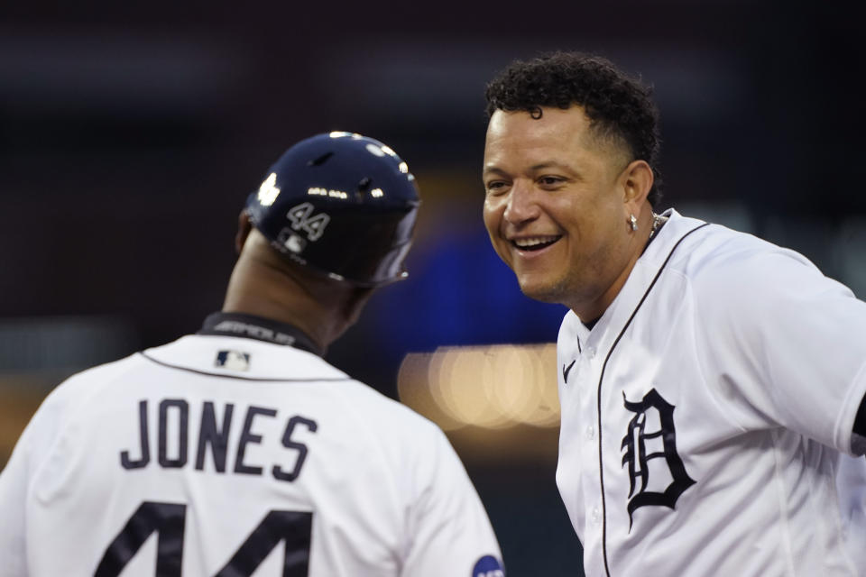 Detroit Tigers designated hitter Miguel Cabrera shares a laugh with first base coach Gary Jones after hitting a single during the fourth inning of a baseball game against the Cleveland Guardians, Thursday, May 26, 2022, in Detroit. (AP Photo/Carlos Osorio)