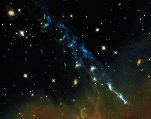 This composite handout image from data taken with Hubble's Advanced Camera for Surveys in 2004 and 2005 and the Wide Field Camera 3 in April 2011 shows Herbig-Haro 110 is a geyser of hot gas from a newborn star that splashes up against and ricochets off the dense core of a cloud of molecular hydrogen, released by NASA on July 3, 2012. Although the plumes of gas look like whiffs of smoke, they are actually billions of times less dense than the smoke from a July 4 firework. This Hubble Space Telescope photo shows the integrated light from plumes, which are light-years across. Astronomers now believe that the nearby HH 270 jet grazes an immovable obstacle, a much denser, colder cloud core, and gets diverted off at about a 60-degree angle. The jet goes dark and then reemerges, having reinvented itself as HH 110.