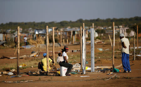 A woman sits in front of her home, which was damaged during the demolition of shacks that triggered riots, north of the South African capital Pretoria, May 24, 2016. REUTERS/Siphiwe Sibeko