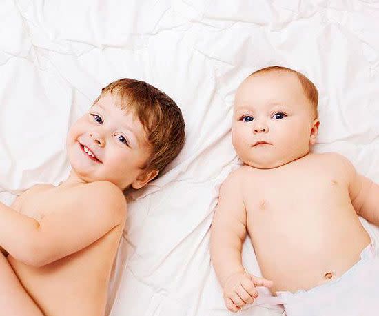 Boy and baby on bed