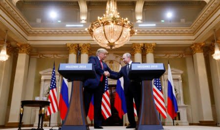 FILE PHOTO: U.S. President Donald Trump and Russia's President Vladimir Putin shake hands during a joint news conference after their meeting in Helsinki, Finland, July 16, 2018. REUTERS/Kevin Lamarque/File Photo