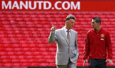 Angel Di Maria (R) speaks with Louis van Gaal as he arrives for a news conference at Old Trafford in Manchester, northern England August 28, 2014. REUTERS/Darren Staples