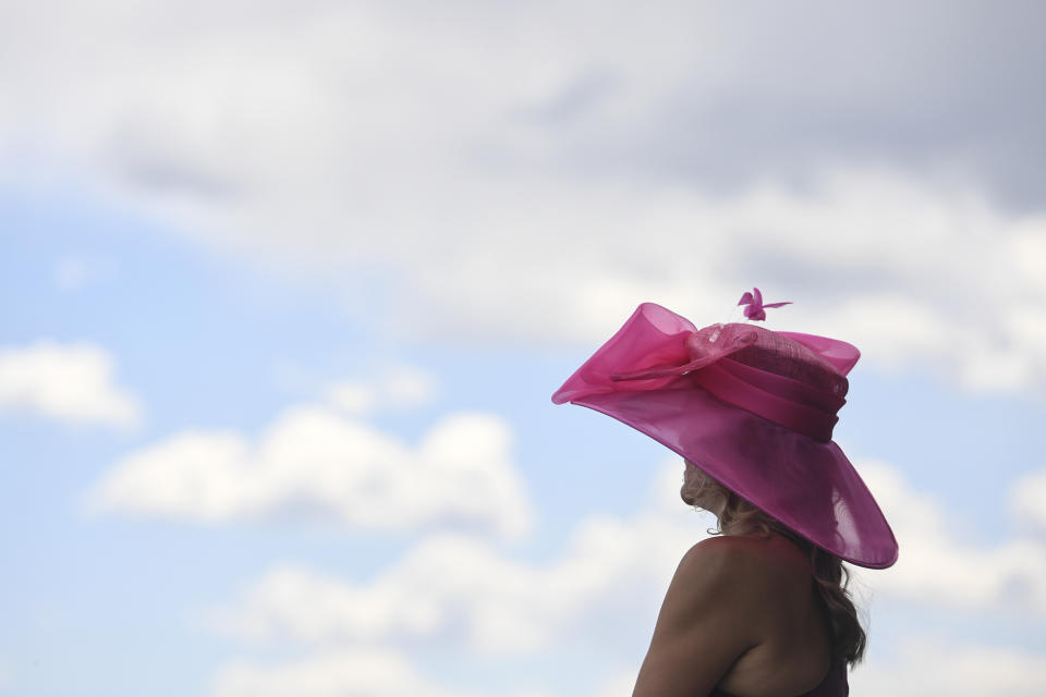 A woman wears a big hat ahead of the Preakness Stakes horse race at Pimlico Race Course, Saturday, May 15, 2021, in Baltimore. (AP Photo/Will Newton)