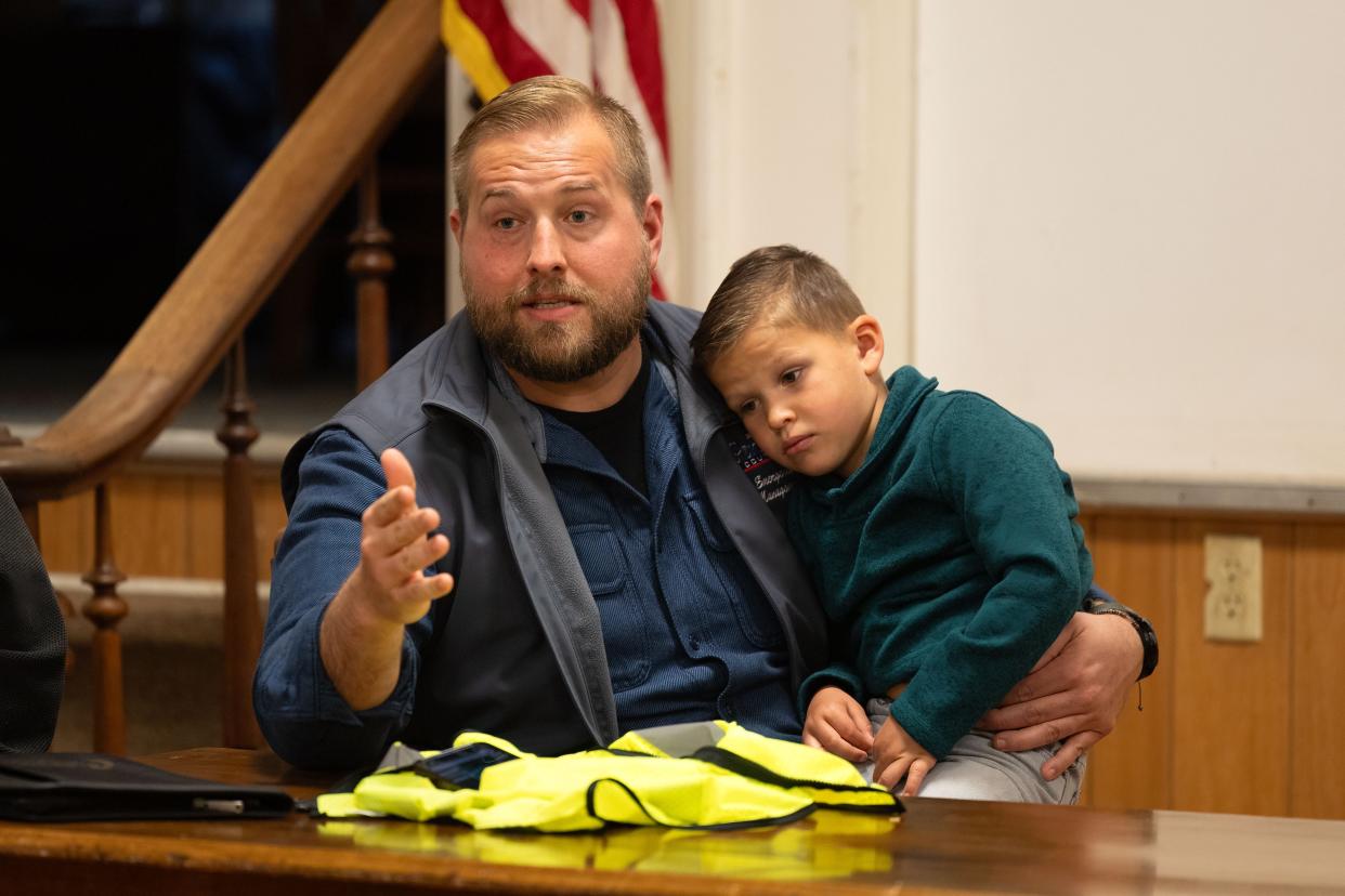 Ryan Shackelford, director of Portage County Emergency Management Agency, addresses the crowd as his 4-year old son Beau sits on his lap Sunday, April 21, 2024, during a public meeting at Windham Town Hall. Officials were on hand to assist residents who have questions or need help after a tornado struck Wednesday, April 17, 2024.