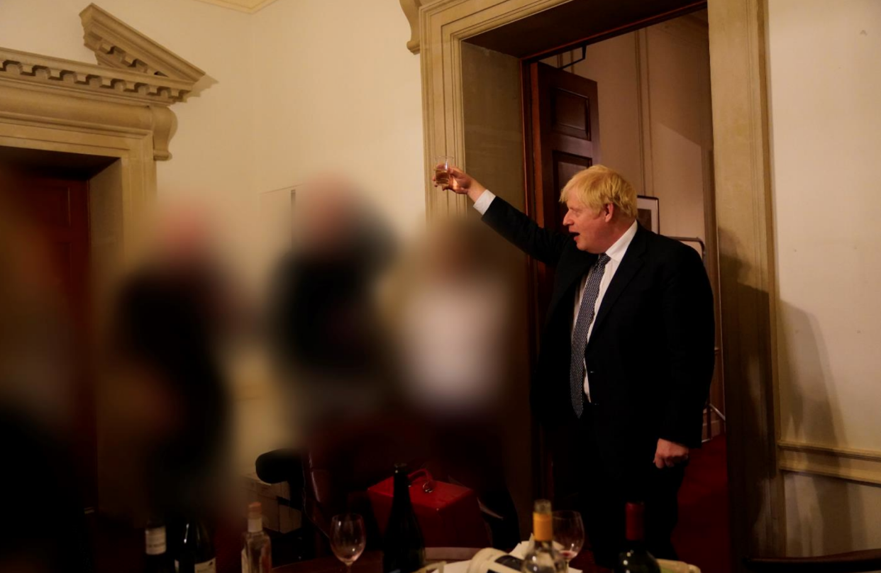 A third image taken on 13 November, 2020, shows Boris Johnson raises his glass and surrounded by bottles. (Cabinet Office)
