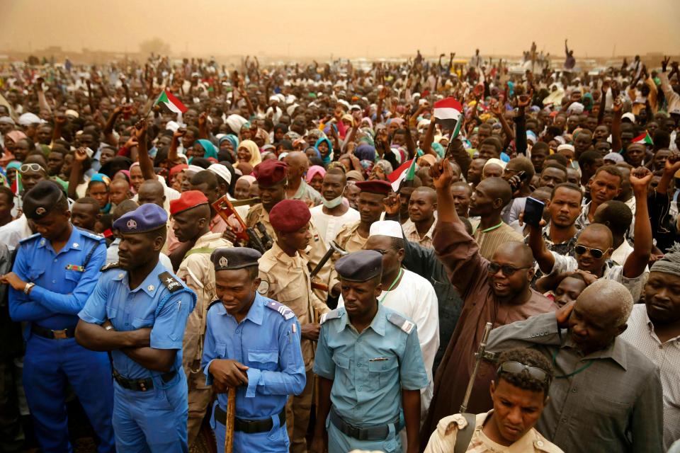 Sudanese policemen stand guard, as supporters of Gen. Mohammed Hamdan Dagalo, the deputy head of the military council, better known as Hemedti, attend a military-backed rally, in Mayo district, south of Khartoum, Sudan, Saturday, June 29, 2019. Sudan's ruling generals say they have accepted a joint proposal from the African Union and Ethiopia to work toward a transitional government.