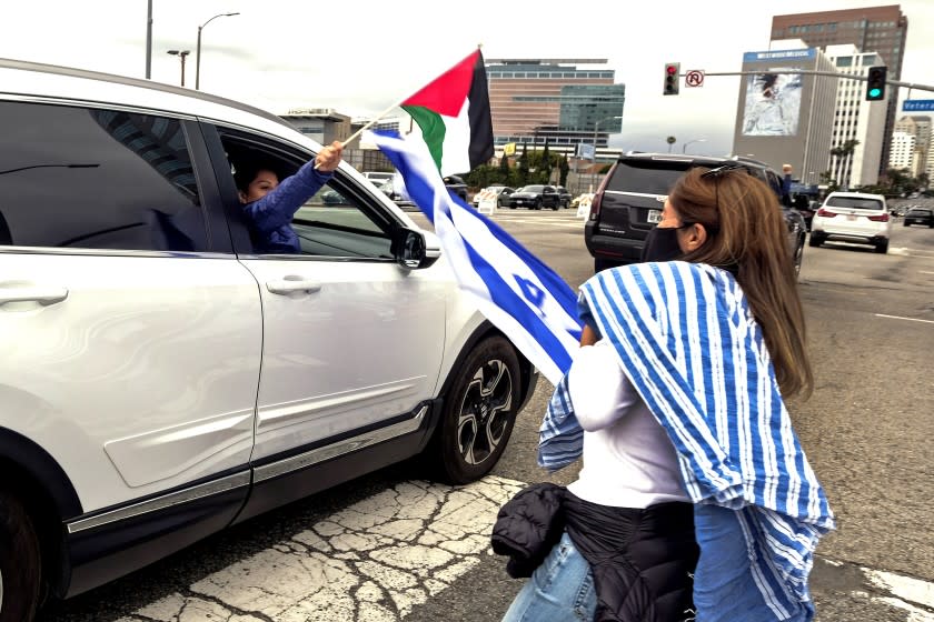 A motorist holding a Palestine flag interacts with a pro Israel demonstrator during a protest outside the Federal Building against Palestine and in support of Israel, Sunday, May 16, 2021 in Los Angeles. (Ringo Chiu via AP)