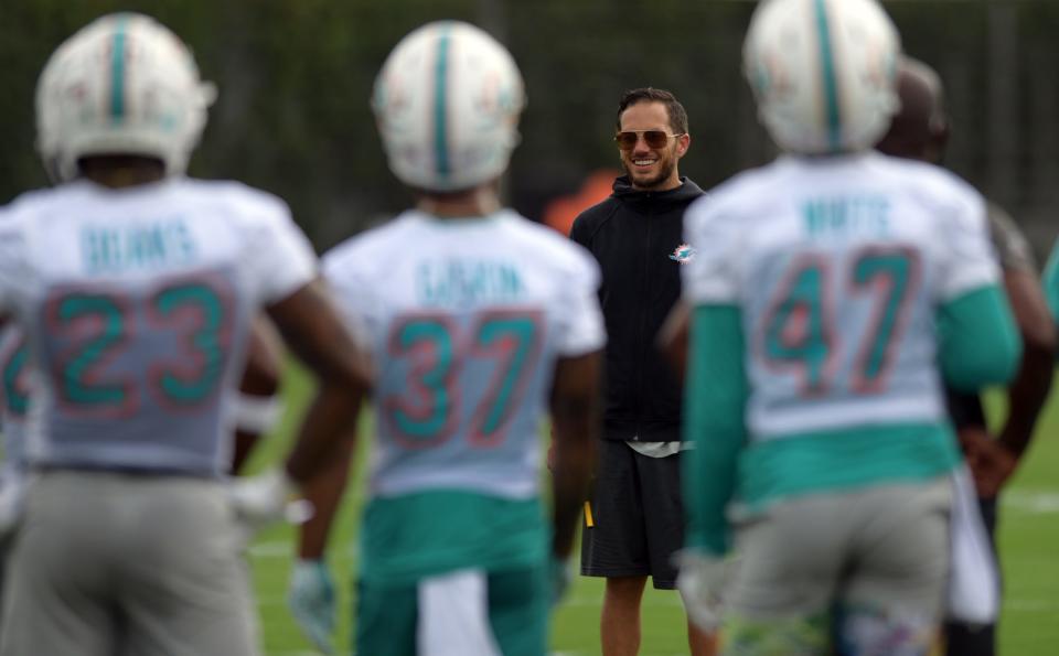 Dolphins coach Mike McDaniel interacts with players during training camp in Miami Gardens.