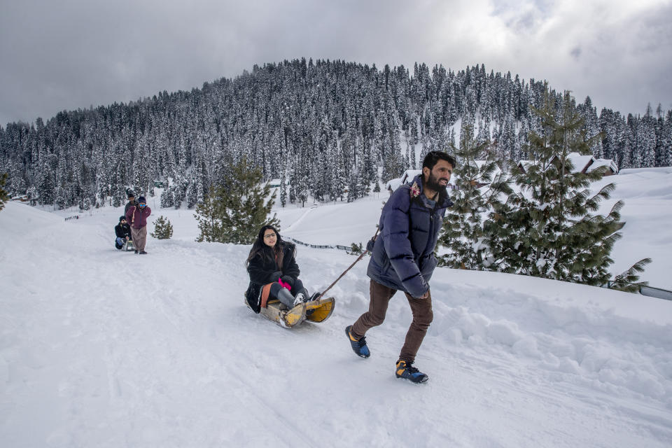 Kashmiris pull Indian tourists on sledges at Gulmarg, northwest of Srinagar, Indian controlled Kashmir, Saturday, Jan. 9, 2021. Snow this winter has brought along with it thousands of locals and tourists to Indian-controlled Kashmir's high plateau, pastoral Gulmarg, which translates as “meadow of flowers." (AP Photo/ Dar Yasin)