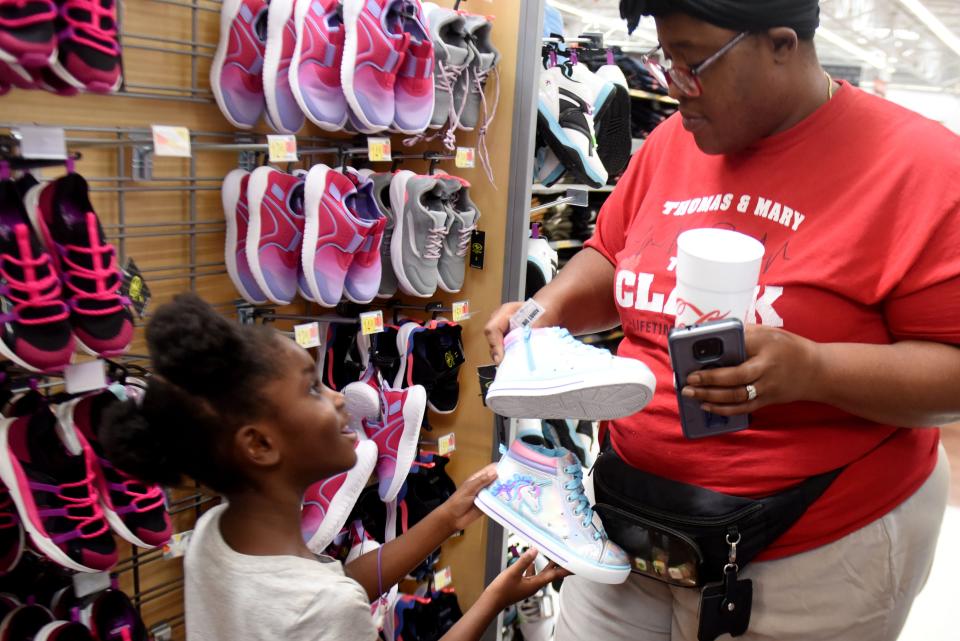 Erica Clark shows her mother, Mylekia Clark, the shoes she wants during the African American Celebration Parade Committee 18th annual Back to School Shoe Giveaway Saturday afternoon, July 30, 2022, at the Walmart on Pines Road.