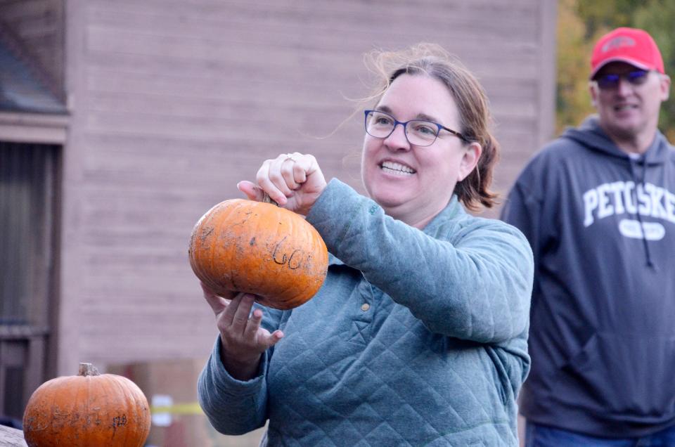 Ashley Whitney shows off the winning pumpkin from the pumpkin roll during the 2021 Fall Fest. The three pumpkins that rolled the farthest down the sledding hill at the Winter Sports Park received prizes.