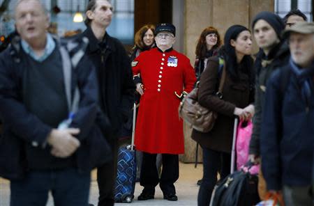 A Chelsea pensioner waits amongst crowds who were delayed or had trains cancelled due to storms, at Waterloo Station in London December 24, 2013. REUTERS/Luke MacGregor