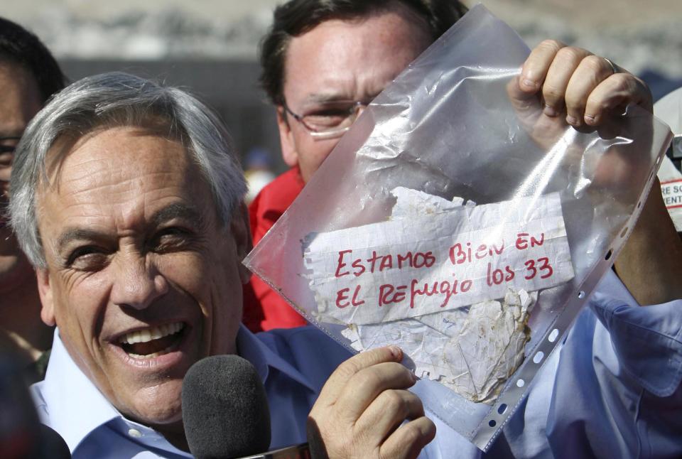 FILE - In this Aug. 22, 2010 file photo, Chile's President Sebastian Pinera holds up a plastic bag containing a message, from miners trapped in a collapsed mine, that reads in Spanish "We are ok in the refuge, the 33 miners" in Copiapo, Chile. Chile marks on Sunday, Aug. 5, 2012 the two year anniversary since 33 miners were trapped in the mine that collapsed and trapped them for 69 days before their rescue. (AP Photo/Hector Retamal, File)