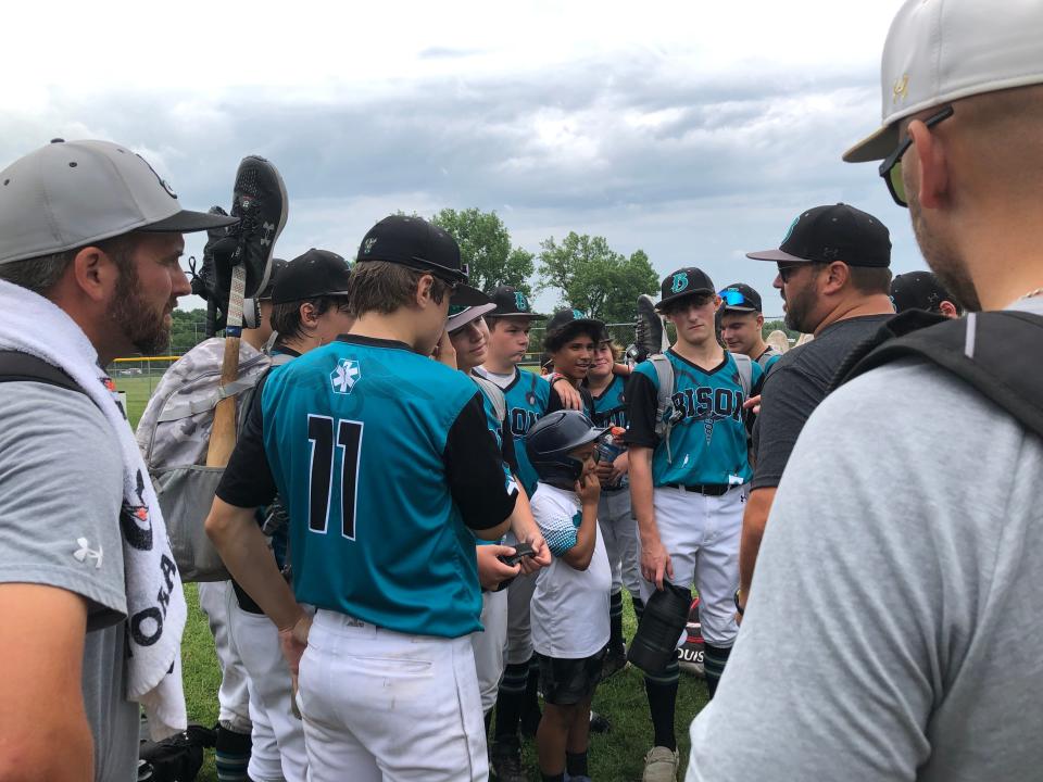 Ohio Bison 13u head coach Mike Kopachy (second from right) talks to his team, after they scored an 8-0 win Saturday morning against Gahanna Blue Lions 13u in the Columbus Classic at Berliner Park.