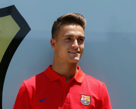 Soccer player Denis Suarez poses next to a FC Barcelona's giant logo at their offices in Barcelona, Spain, July 5, 2016. REUTERS/Albert Gea