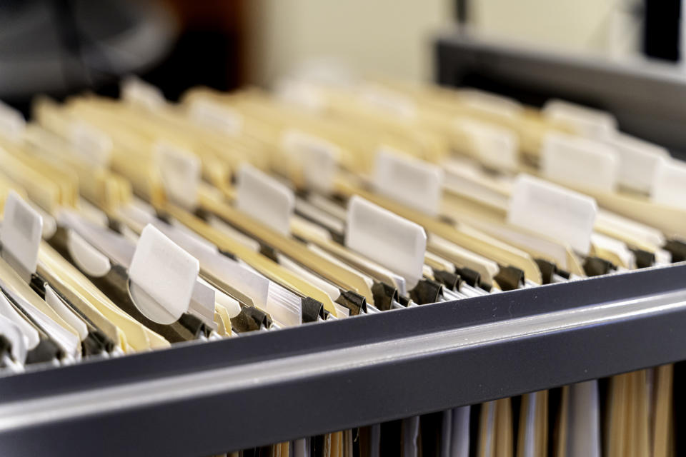 Close-up of a drawer filled with labeled hanging file folders, representing organized documents in an office setting