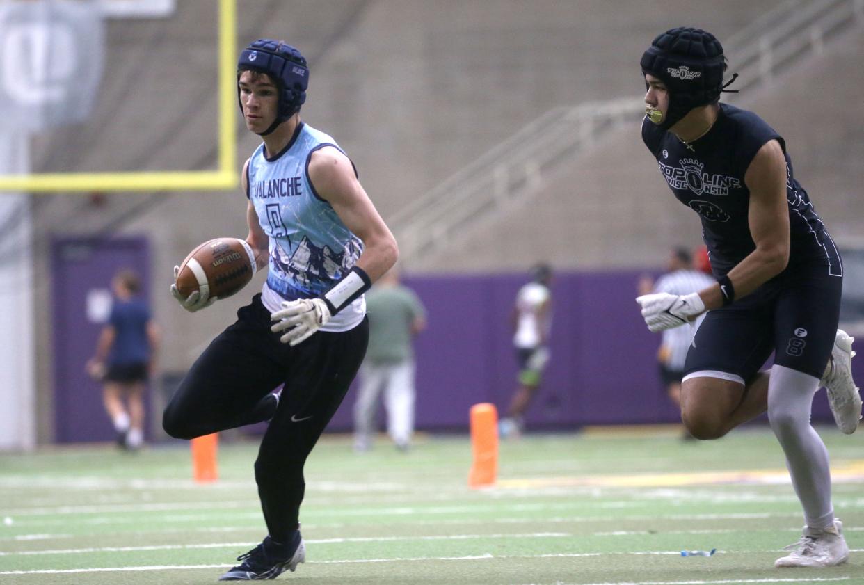 Andrew Greve, left, runs for extra yards after catching the ball during a 7-on-7 football tournament Saturday at the UNI Dome in Cedar Falls.