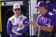 Denny Hamlin, left, talks to a crew member prior to practice and qualifying at Richmond Raceway for Sunday's NASCAR Cup Series auto race Saturday, Aug. 13, 2022, in Richmond, Va. (AP Photo/Steve Helber)