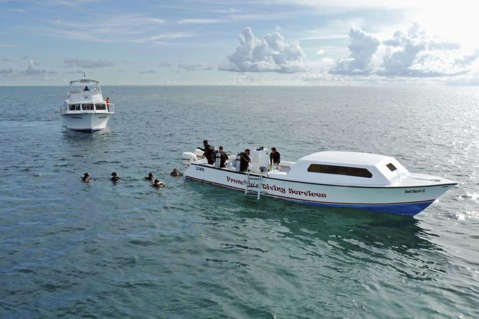 Scuba divers exit a dive boat in Belize
