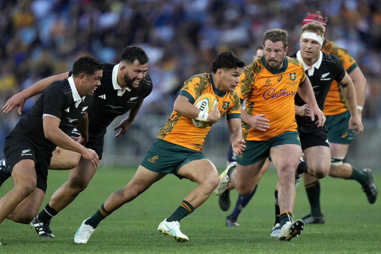 Australia's Noah Lolesio, center, looks make break against New Zealand during their rugby union test match in Sydney, Saturday, Sept. 21, 2024. (AP Photo/Rick Rycroft)